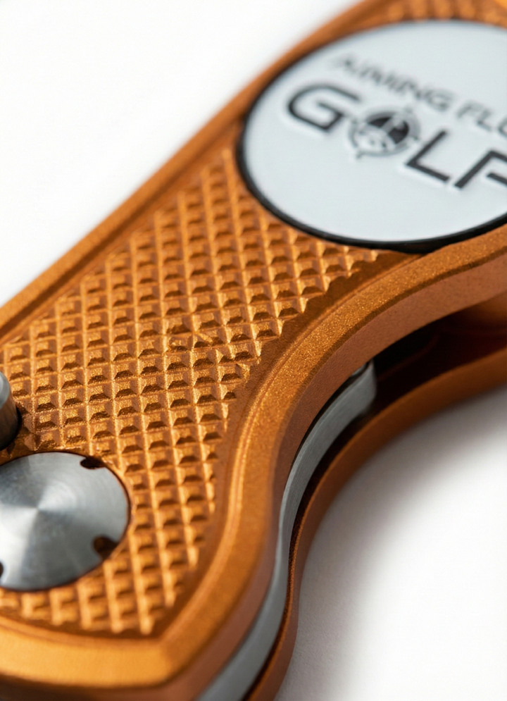 Limited edition divot tool in orange with textured grip and silver logo, designed for golf course maintenance.