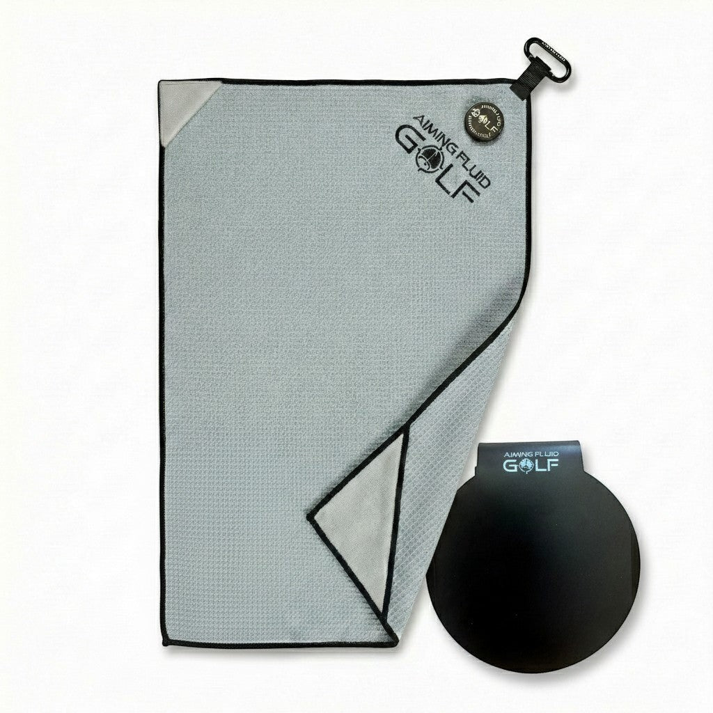 Aiming Fluid Golf grey waffle weave microfiber golf towel with black trim and a black magnetic landing pad accessory.